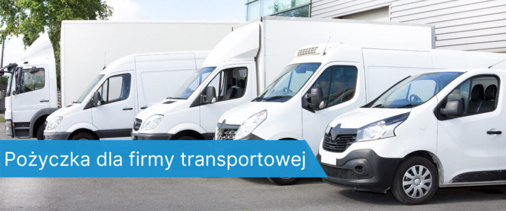 Kilka białych aut dostawczych i ciężarówek zaparkowanych obok siebie przed halą