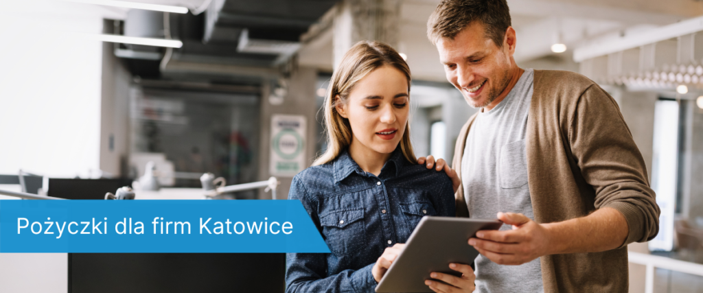 Kobieta i mężczyzna stoją razem w nowoczesnym biurze, patrzą na ekran tabletu z uśmiechem